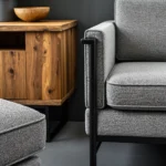 Industrialny fotel szary z metalową ramą i drewniana komoda orzech